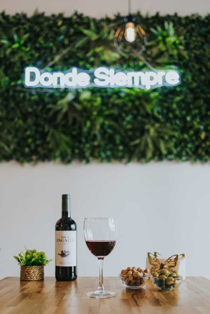 Copa de vino tinto servida junto a aperitivo en restaurante Donde Siempre Gandía