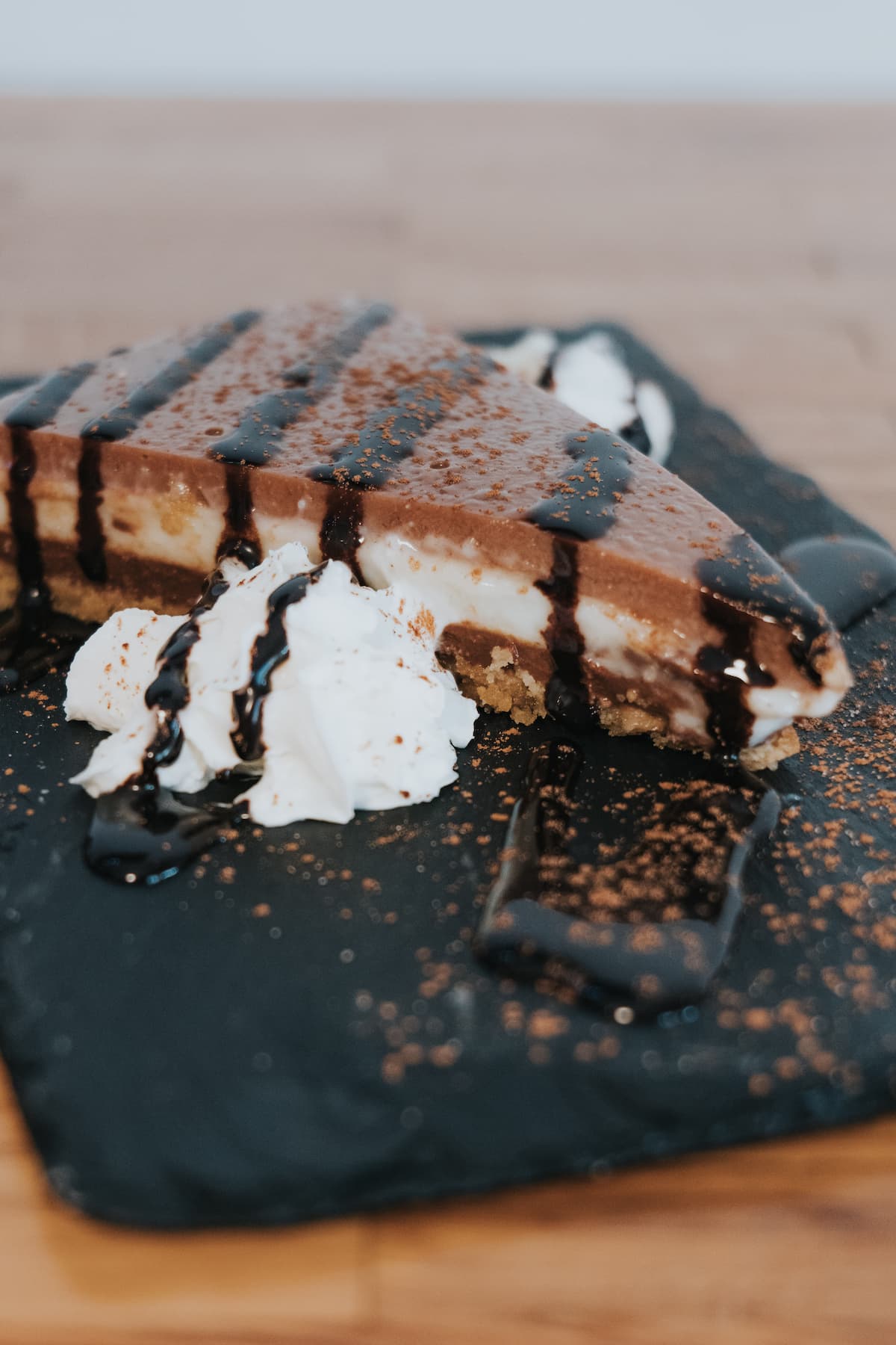 Tarta de tres chocolates con nata montada, servida como postre en Donde Siempre